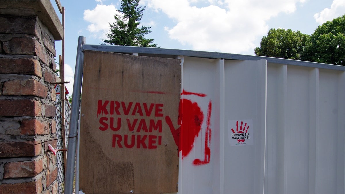 Red handprint and text on a fence